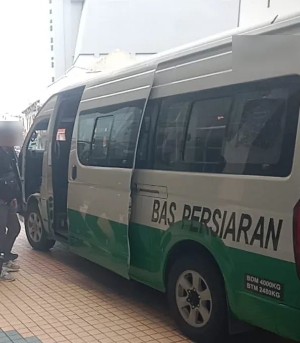 Tour van collecting a visiting team at a hotel in Melaka town