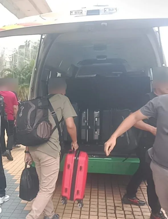 Driver and passengers loading luggage into the van